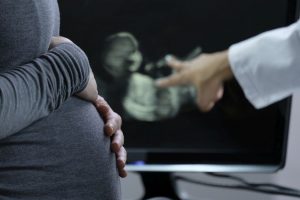 Doctor showing ultrasound image to pregnant woman